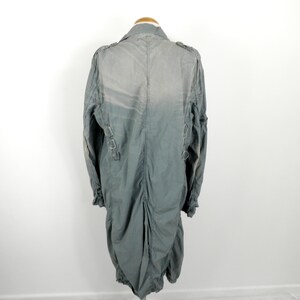 May include: A long, gray, lightweight jacket with a zipper closure and a stand-up collar. The jacket has a cinched waist and a slightly gathered back.