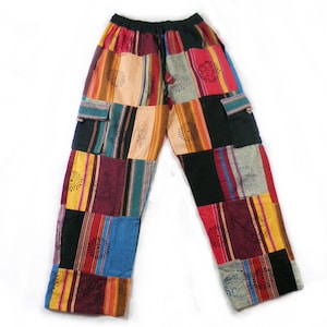 Può includere: Pantaloni patchwork con un design colorato che presenta strisce, quadrati e motivi floreali. I pantaloni hanno una vita con coulisse e due tasche laterali.