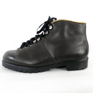 May include: A pair of brown leather hiking boots with black laces and a rubber sole.