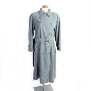 May include: A long, grey double-breasted trench coat with a belt and gold buttons.