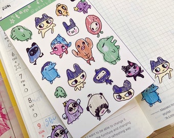 May include: A sheet of paper with hand-drawn illustrations of colorful cartoon characters. The characters are various colors and have different features, such as hats, wings, and tails. The paper has the text "#tama friends!" and "@wentko" written on it.