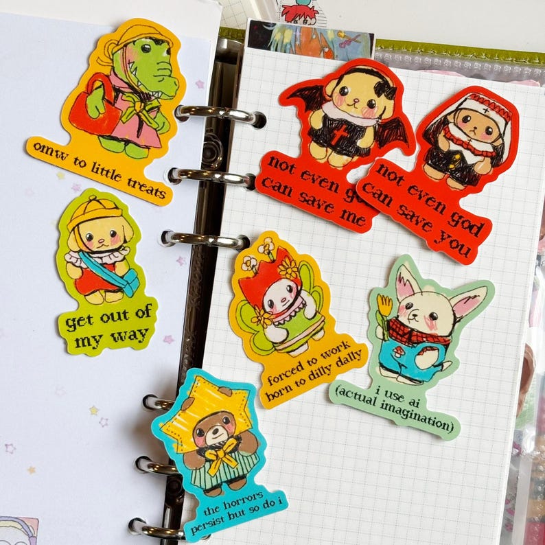 May include: A collection of colorful stickers featuring cartoon characters with various phrases. The stickers include a green alligator, a puppy, a bear, and a bunny. Phrases include "omw to little treats" and "not even god can save you."