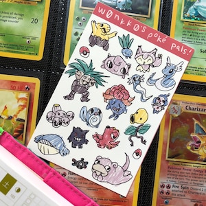 May include: A sheet of stickers featuring hand-drawn Pokémon characters in various colors. The sheet is titled "wonkko's poké pals!" and is placed next to vintage Pokémon trading cards. The stickers include Bulbasaur, Charmander, and Charizard.