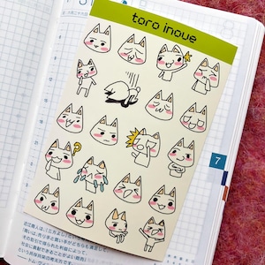 May include: A sheet of stickers featuring various illustrations of white cats with different facial expressions. The stickers are on a white background with black outlines. The text "toro inoue" is printed in green at the top of the sheet.