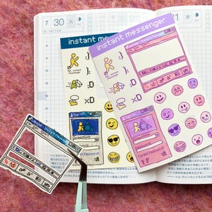 May include: A set of three stickers featuring a retro computer interface design. The stickers are pink, purple and blue with a white outline. The stickers feature a computer window with the text "Instant Messenger" and a variety of emoticons.
