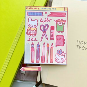 May include: A sheet of stickers featuring cute cartoon bears, stationery items, and the words "hello" and "diary". The stickers are on a light pink background with a white border.