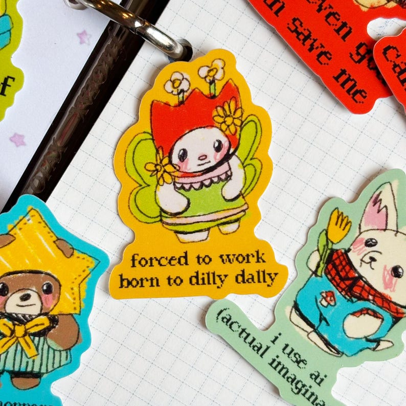 May include: A collection of colorful stickers with cartoon characters and text. One sticker features a fairy-like character with a red crown and the text "forced to work born to dilly dally."