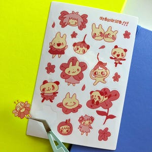 May include: A sheet of stickers featuring cute cartoon characters with pink and red accents. The stickers are on a white background and include a variety of characters, including animals, flowers, and people. The text "WONKY NO!!" is printed in the top right corner of the sheet.