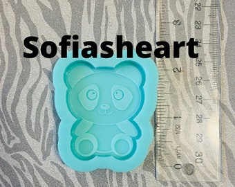 May include: A light blue silicone mould shaped like a panda bear. The mould is approximately 6.5 cm tall and 5 cm wide. The panda bear has black eyes, a black nose, and black ears.