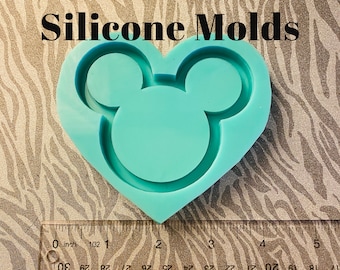 May include: A light blue silicone mould shaped like a heart with Mickey Mouse ears. The mould is approximately 5 cm wide.