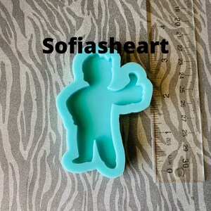 May include: A turquoise blue silicone mold of a cartoon character giving a thumbs up. The mold is approximately 2.5 inches tall.