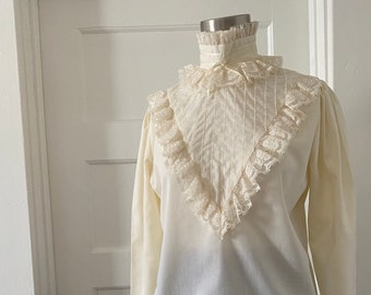 Blusa victoriana vintage de manga larga de los años 70 con jabot y cuello con volantes, blusa victoriana de encaje de color crema de los años 70 con detalle de lazo de cuello embudo