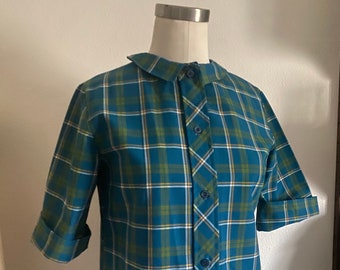 May include: A blue and green plaid shirt dress with a collared neckline and button closure. The dress has short sleeves and a relaxed fit.