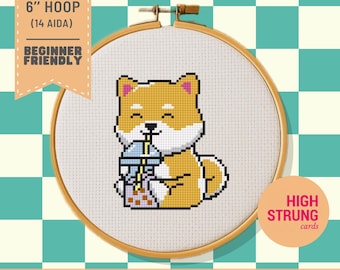 Pode incluir: Um padrão de ponto cruz num bastidor de madeira com um cão Shiba Inu bege e branco a beber chá de bolhas com uma palhinha amarela. O texto diz: FITS ON 6" HOOP (14 AIDA) BEGINNER FRIENDLY, HIGH STRUNG cards, PATTERN KEEPER STITCHLY PDF FILES.