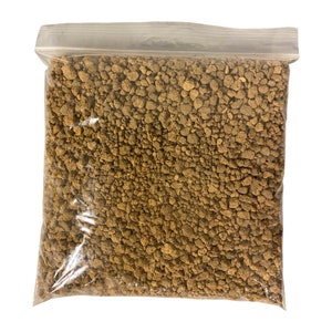 May include: A clear plastic bag filled with brown, crumbly soil. The soil is a loose, granular texture.