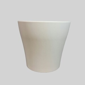 May include: A white ceramic planter with a rounded bottom and a wide opening. The planter is smooth and has a matte finish.