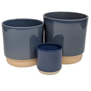 May include: Three ceramic plant pots in different sizes, all with a blue glaze and a light pink rim. The largest pot is the darkest blue, the medium pot is a lighter blue, and the smallest pot is a deep blue.