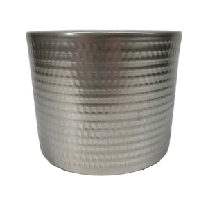 May include: A silver ceramic planter with a textured, hammered finish. The planter has a cylindrical shape and a smooth, rounded rim.