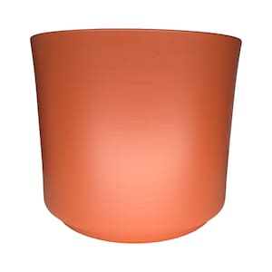 May include: A terracotta-coloured cylindrical planter with a slightly curved base. The planter has a smooth, matte finish and is suitable for indoor or outdoor use. The design is simple and modern, perfect for showcasing plants.