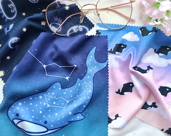May include: Three microfiber cleaning cloths with different designs. One cloth features a blue whale with a constellation of stars, another has a blue and white jellyfish pattern, and the third has a pink and blue sky with white clouds and black whales.