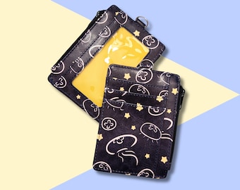 May include: Two black card holders with a jellyfish pattern. One card holder has a clear plastic window.