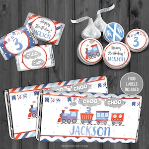 May include: Printable train-themed party favour labels for chocolate bars. The labels feature a blue train with red and white accents, a red caboose, and the words "Choo Choo" and "Jackson".