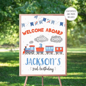 May include: A wooden framed sign with a train design. The sign says "WELCOME ABOARD" in red, and "JACKSON'S 3rd birthday" in blue. The sign includes a train illustration and the words "CHOO CHOO".