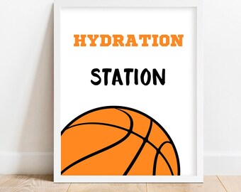 以下が含まれることがあります： 白枠のプリントに、黒とオレンジの文字で「HYDRATION STATION」と書いてあります。プリントの下部には、バスケットボールが一部見えています。