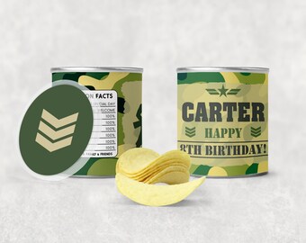 以下が含まれることがあります： 緑、茶色、白の迷彩柄のチップス缶。缶には「CARTER」と「HAPPY 8TH BIRTHDAY!」の文字が印刷されている。缶は白い表面に置かれ、その前にポテトチップスの山が置かれている。