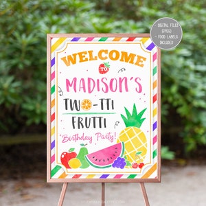 May include: A colorful welcome sign for a birthday party with the text "Welcome to Madison's Two-tti Frutti Birthday Party!" The sign features a pineapple, watermelon, and other fruits.