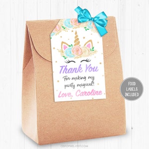 May include: A white thank you tag with a unicorn face illustration, gold glitter stars, and the text "Thank You For making my party magical! Love, Caroline". The tag is attached to a brown paper bag.
