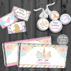 May include: Printable unicorn-themed party favour bag toppers with a gold glitter background. The toppers feature a unicorn with a floral crown, a rainbow, and the text "Happy Birthday! Caroline".