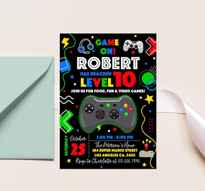 K&ouml;nnte beinhalten: Eine schwarze und neongr&uuml;ne Videospiel-Geburtstagseinladung zum 10. Geburtstag von Robert. Die Einladung zeigt einen gro&szlig;en schwarzen und gr&uuml;nen Videospiel-Controller, den Text "GAME ON!" und "ROBERT HAS REACHED LEVEL 10" sowie das Datum und die Uhrzeit der Party.