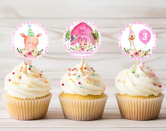Könnte beinhalten: Drei rosa und weiße Cupcake-Topper mit Bauernhoftier- und Scheunendesigns. Die Topper zeigen ein Schwein, eine Gans und eine Scheune mit dem Text "Amanda".