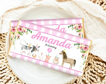 Puede incluir: Envoltorio de barra de chocolate a rayas rosas y blancas con un diseño floral y animales de granja. El envoltorio dice "Amanda cumple 3 años".