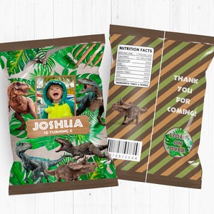 Può includere: Un sacchetto di carta marrone a tema dinosauri. Il sacchetto ha una foto di un bambino davanti a una scena di giungla verde con dinosauri. Il testo sul sacchetto dice "Joshua compie 5 anni". Il retro del sacchetto ha un motivo a strisce verdi e marroni con il testo "Grazie per essere venuto!" e "Calpesta sopra".