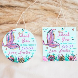 May include: Two round and square thank you tags with a mermaid tail design. The tags are light blue with a pink and purple mermaid tail, seashells, and the text "Thank You for making my party a Splash! Love, Amelia".