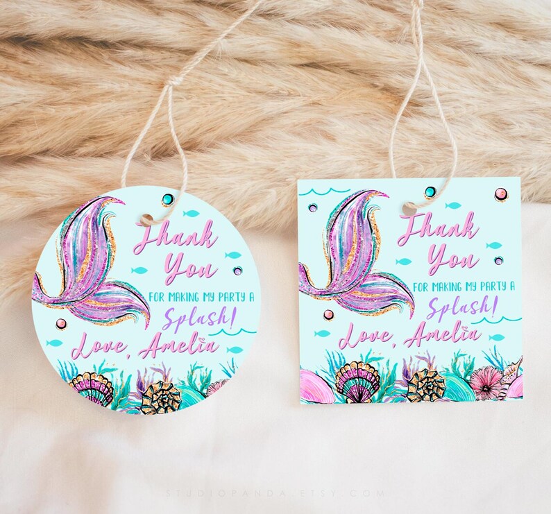 May include: Two round and square thank you tags with a mermaid tail design. The tags are light blue with a pink and purple mermaid tail, seashells, and the text "Thank You for making my party a Splash! Love, Amelia".