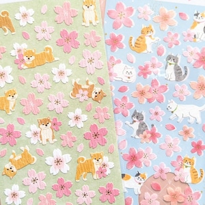 May include: Two sticker sheets with Japanese Shiba Inu dogs and cats, surrounded by pink cherry blossoms. The stickers are on green and blue backgrounds. The text "MIND WAVE INC" and Japanese characters are visible.