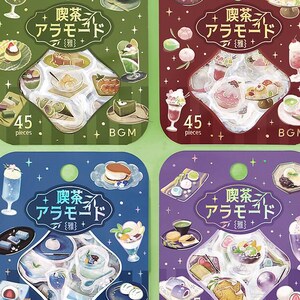 May include: Four sticker sheets with Japanese dessert illustrations. Each sheet is a different color: green, red, blue, and purple. Each sheet has the text "喫茶 アラモード" and "45 pieces". The stickers depict various sweets and drinks.
