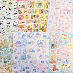 May include: A selection of colourful sticker sheets showcasing cartoon characters. Designs include pandas, bears, whales, and Sanrio characters. The stickers are in various shapes and sizes, with a pastel colour palette.