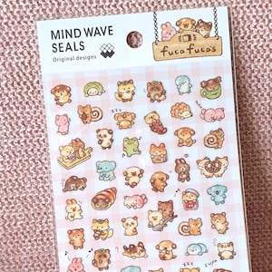 May include: A sheet of Mind Wave Seals stickers with original designs. The stickers feature various cartoon animals, including bears, bunnies, and frogs, in a variety of poses and colours. The sheet also includes the text "fuca fuca's".