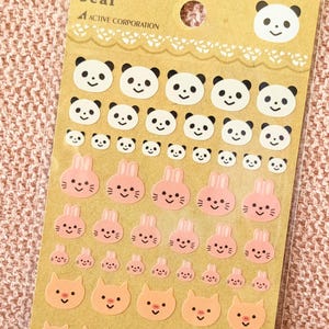 May include: A sheet of decorative stickers featuring panda bears, pink bunnies, and peach-colored pigs. The stickers vary in size and are arranged in rows. The text "ACTIVE CORPORATION" is visible at the top of the sheet.