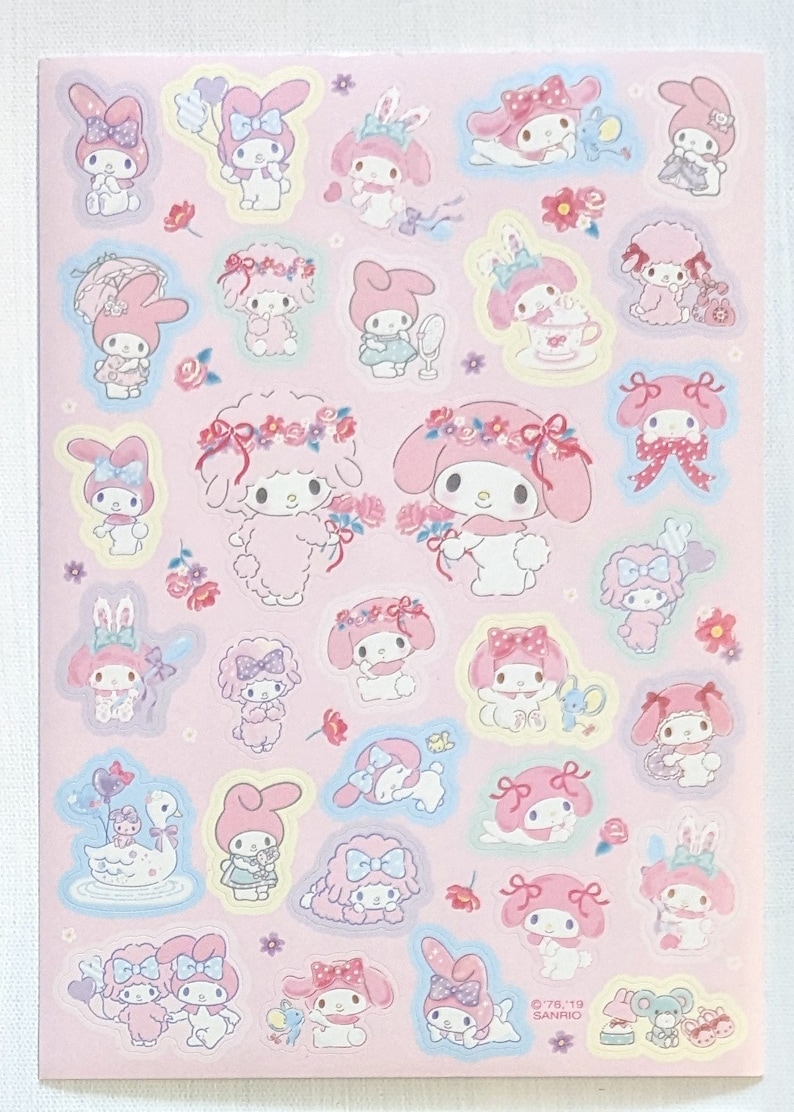 May include: A sheet of pink stickers featuring illustrations of a cartoon character with a pink bow and bunny ears. The stickers have a light blue outline and include flowers and other decorative elements.