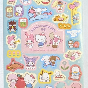 May include: A sheet of colourful Sanrio character stickers on a light blue background. The stickers feature various characters like Hello Kitty, My Melody, and others, with the text "Sanrio characters" and "Enjoying fun days together!".