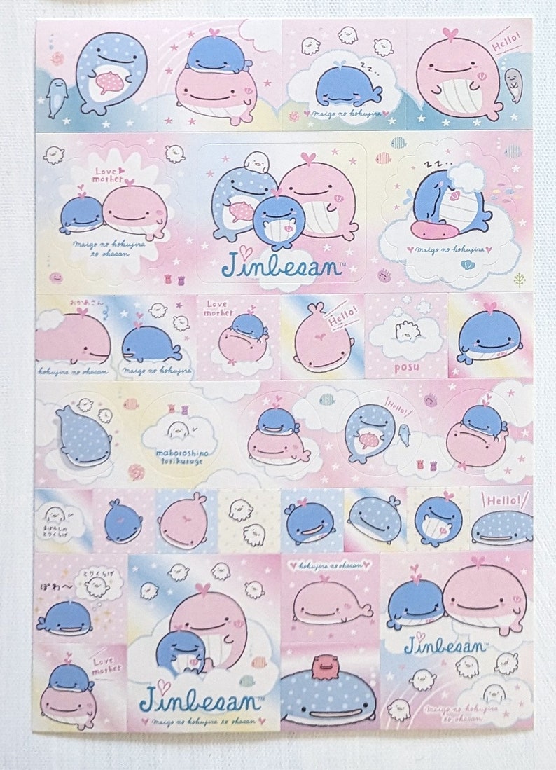 May include: A sheet of stickers featuring cartoon whales in various poses. The stickers are primarily pink and blue, with some text and cloud designs. The text includes "Hello!" and "Jinbesan".