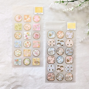 Op de afbeelding: Twee vellen met decoratieve stickers met een Japans thema. De stickers zijn in verschillende vormen en maten en hebben ingewikkelde patronen en ontwerpen in roze, blauwe en gouden tinten. De stickers zijn verpakt in doorzichtige plastic zakjes met de tekst "NB COLOR STICKER" erop gedrukt.