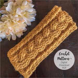 May include: A crocheted headband in a mustard yellow color with a braided pattern. The headband is on a wooden surface with a white flower in the background. The text "Crochet Pattern" is written in black cursive font with the words "Digital Download PDF" below it.