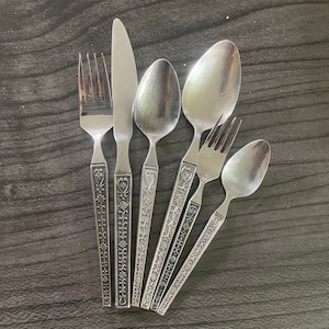 Può includere: Un set di sei pezzi di posate argentate con disegni decorativi. Il set comprende una forchetta, un coltello e quattro cucchiai.