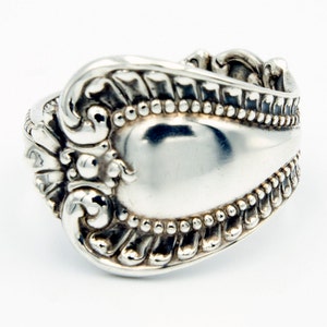 May include: A silver ring made from a repurposed spoon with an ornate design.